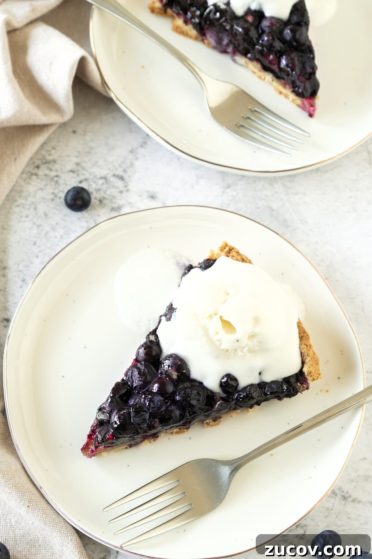 Gluten-Free Blueberry Pie Recipe (Dairy-Free) GF blueberry pie and a fork on a white plate.