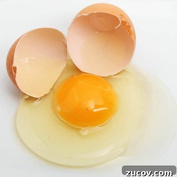 Egg Facts: 10 Frequently Asked Questions About Eggs 8 egg cracked open and spilled on white surface. egg yolk is floating in centre of white