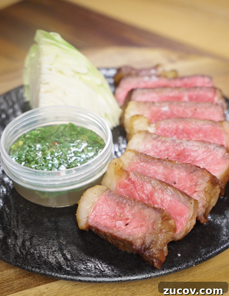 Crying Tiger Steak Recipe: Grilled Thai Marinated Flank Steak 2 Finished Crying Tiger Steak sliced medium-rare and served with a Thai-style dipping sauce, fresh cabbage, and flaky salt on a black plate.