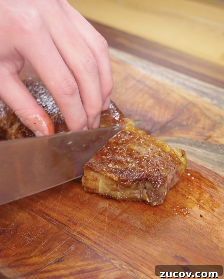 Crying Tiger Steak Recipe: Grilled Thai Marinated Flank Steak 7 Cooked Crying Tiger Steak being sliced thinly against the grain on a wooden cutting board for optimal tenderness.