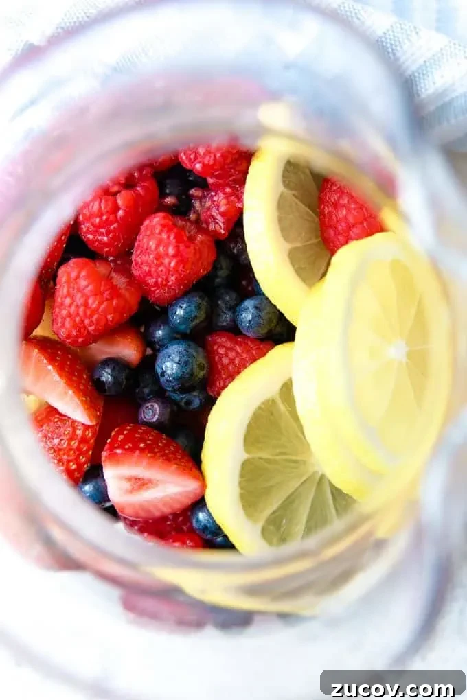 Berry Rosé Sangria Recipe for Summer Parties 3 berries and lemon slices in a pitcher