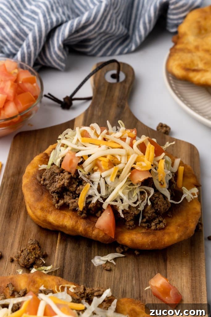Navajo Tacos: Authentic Indian Fry Bread Recipe & Tips 3 navajo tacos on indian fry bread on a wooden cutting board