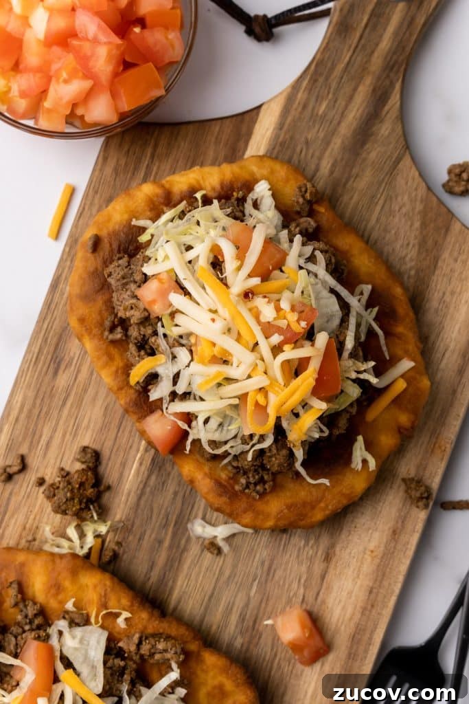 Navajo Tacos: Authentic Indian Fry Bread Recipe & Tips 4 navajo tacos on indian fry bread on a wooden cutting board