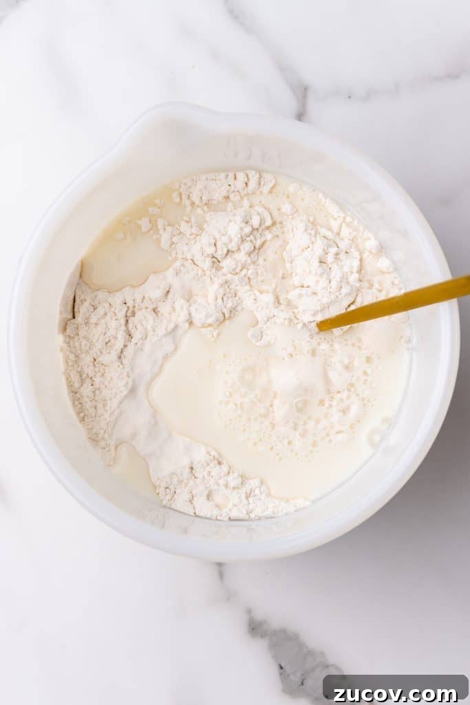 Navajo Tacos: Authentic Indian Fry Bread Recipe & Tips 6 Indian fry bread batter being mixed up in a white bowl with a wooden spoon