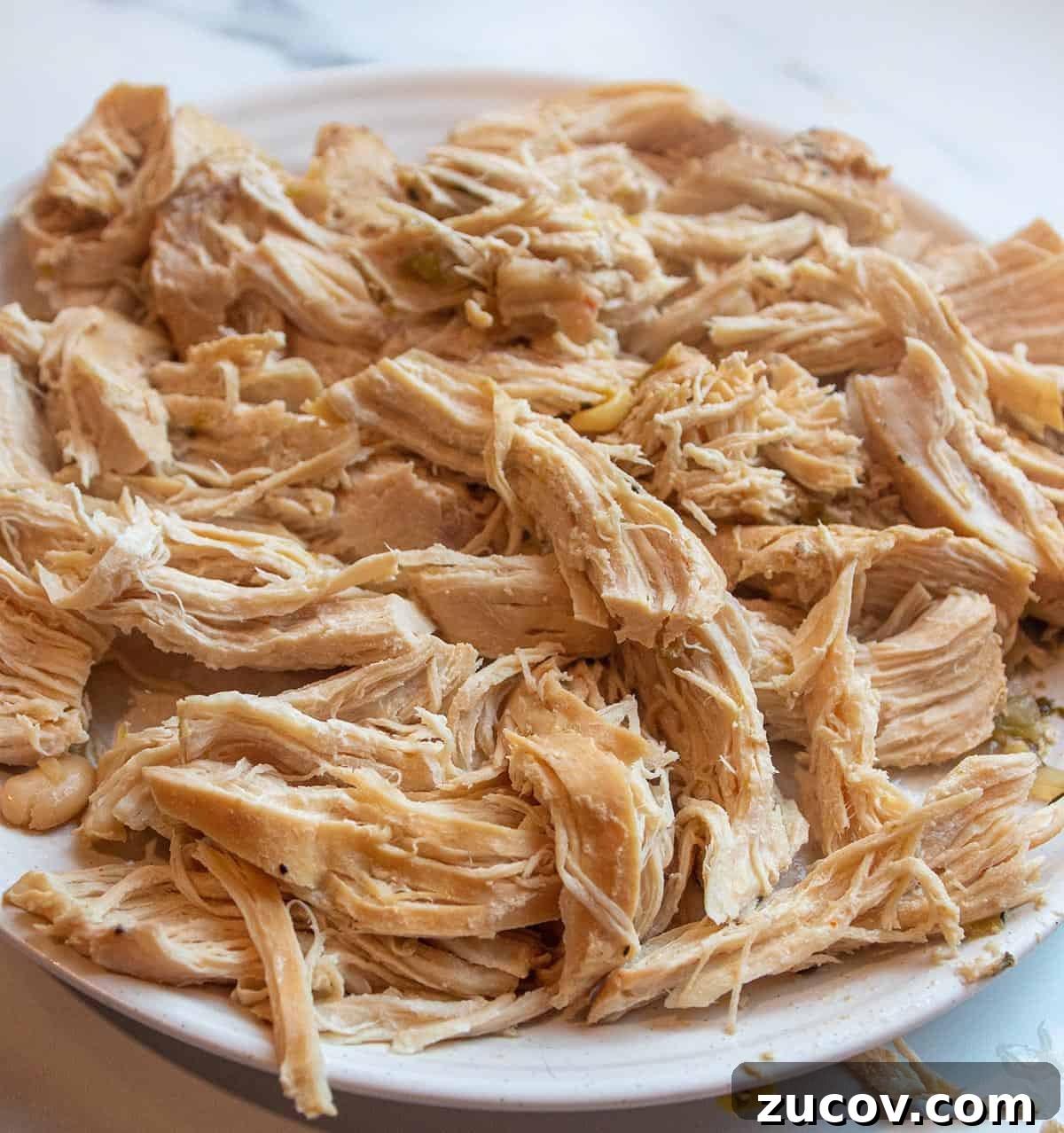 Slow-Cooker Creamy White Chicken Chili Recipe 6 plate full of shredded chicken.