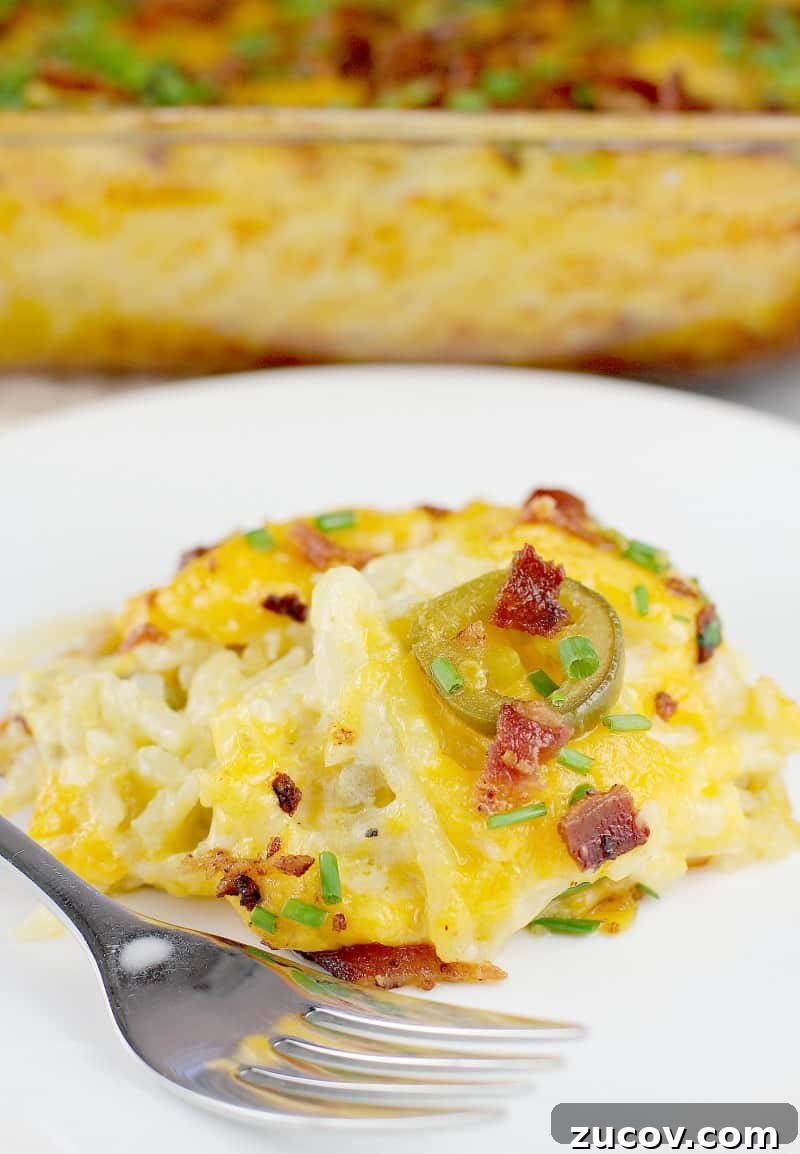 Jalapeño Popper Hash Brown Casserole Recipe for Spicy Comfort 2 plated serving of hash brown casserole on a white plate with a fork