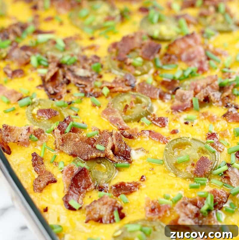 Jalapeño Popper Hash Brown Casserole Recipe for Spicy Comfort 3 cooked casserole in bake dish topped with cheese, bacon, and jalapenos, close view