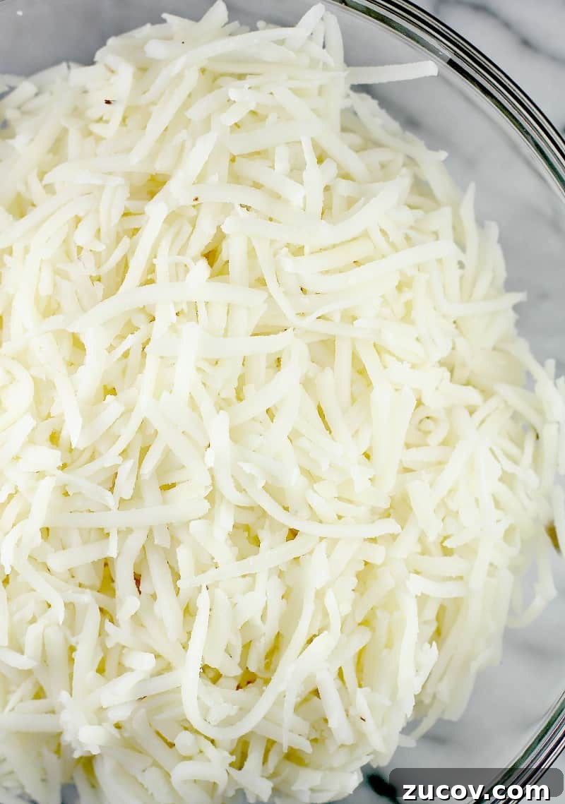 Jalapeño Popper Hash Brown Casserole Recipe for Spicy Comfort 4 shredded potatoes in glass bowl