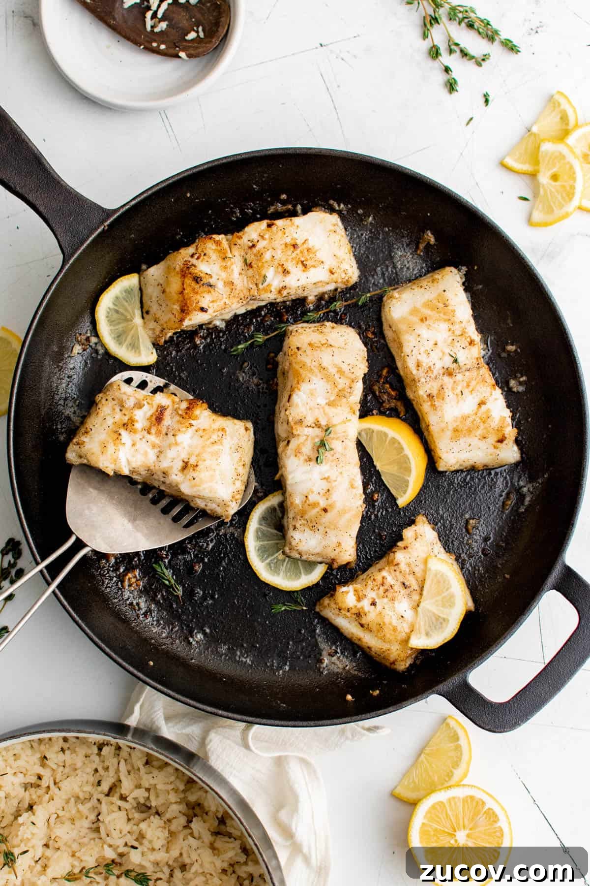 Pan-Seared Chilean Sea Bass with Garlic Herb Rice Recipe 2 five slices of sea bass in a cast iron pan