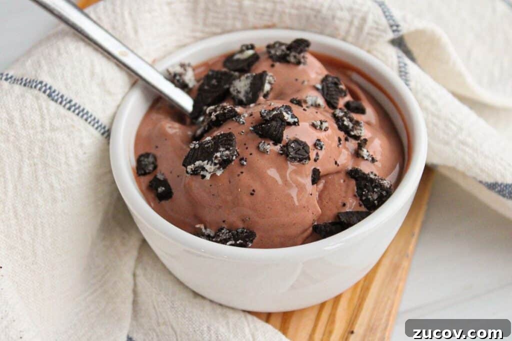 Creamy Cottage Cheese Ice Cream Recipe for Ninja Creami 2 A bowl of chocolate cottage cheese ice cream made with the ninja creami machine in a small white bowl, topped with crushed Oreos.