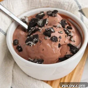 A bowl of chocolate cottage cheese ice cream made with the ninja creami machine in a small white bowl, topped with crushed Oreos.