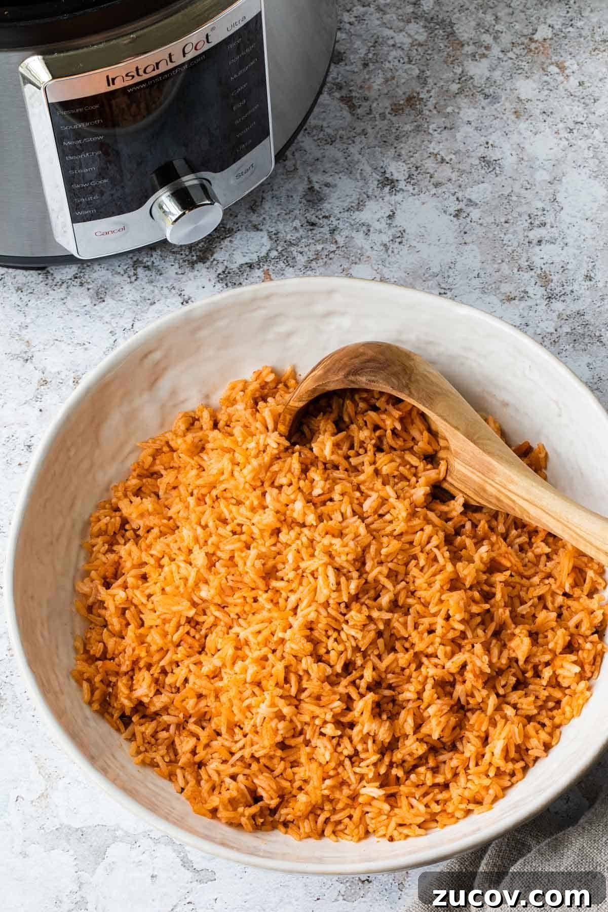 Instant Pot Arroz Rojo (Mexican Red Rice) 2 mexican rice in a white bowl with instant pot in the background