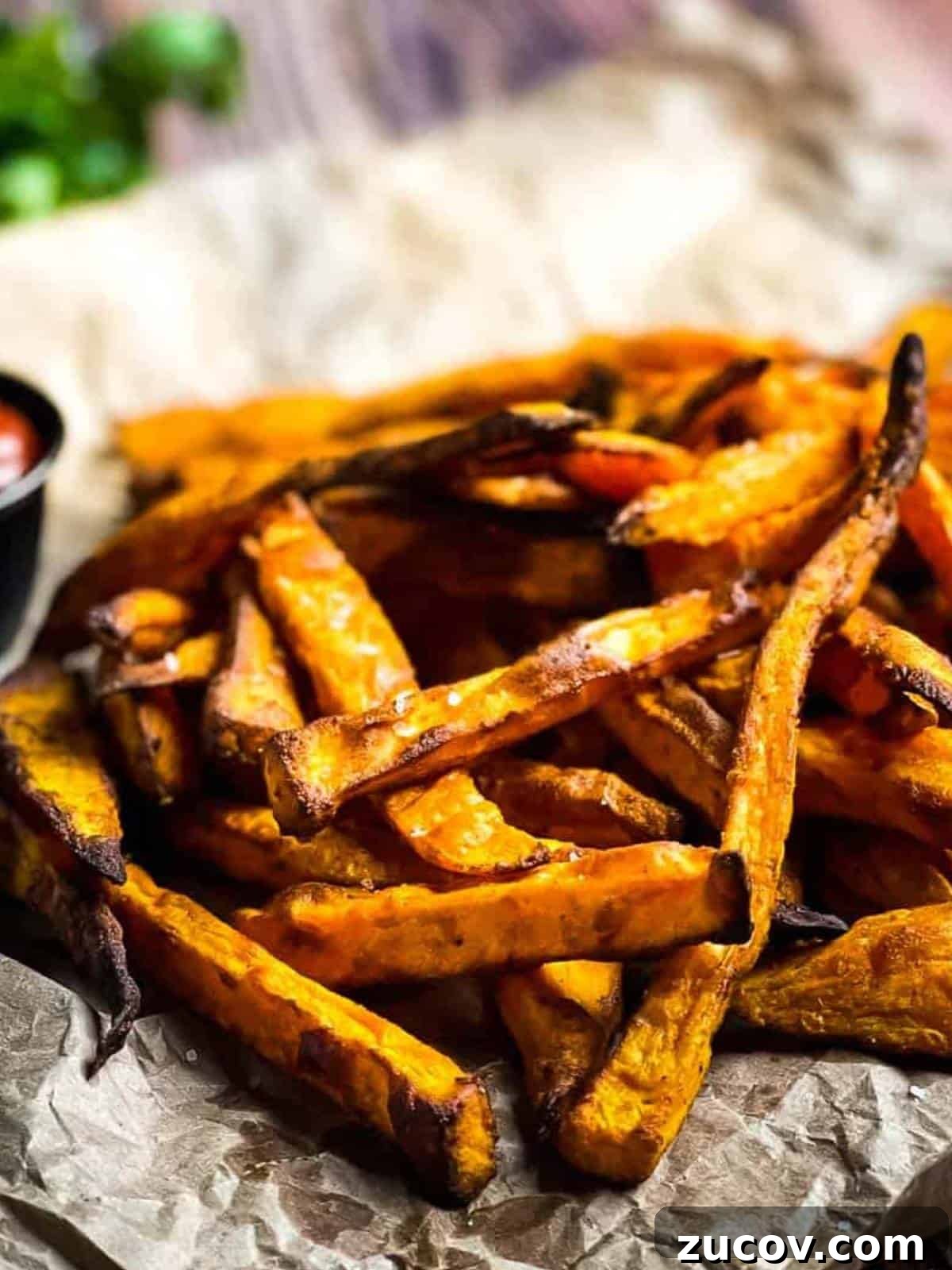 Crispy Air-Fryer Sweet Potato Fries Coated in Cornstarch 13 Crispy air fryer sweet potato fires on brown paper with a side of ketchup.