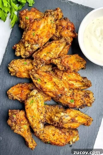 Extra crispy air fryer chicken wings on a serving tray with ranch dipping sauce.