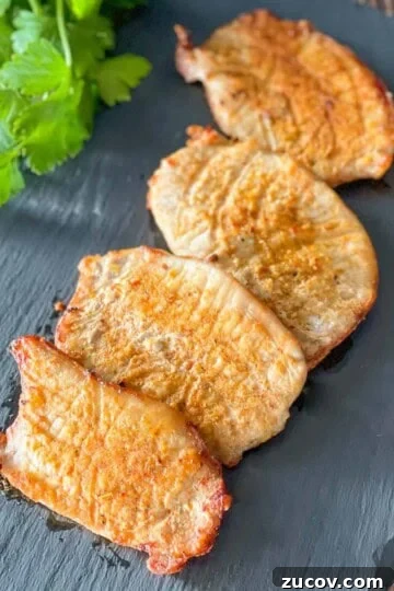 Thin air fried pork chops on a serving platter.