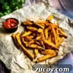 Crispy Air-Fryer Sweet Potato Fries Coated in Cornstarch 20 Ultra crispy sweet potato fries on brown paper with a side of ketchup.
