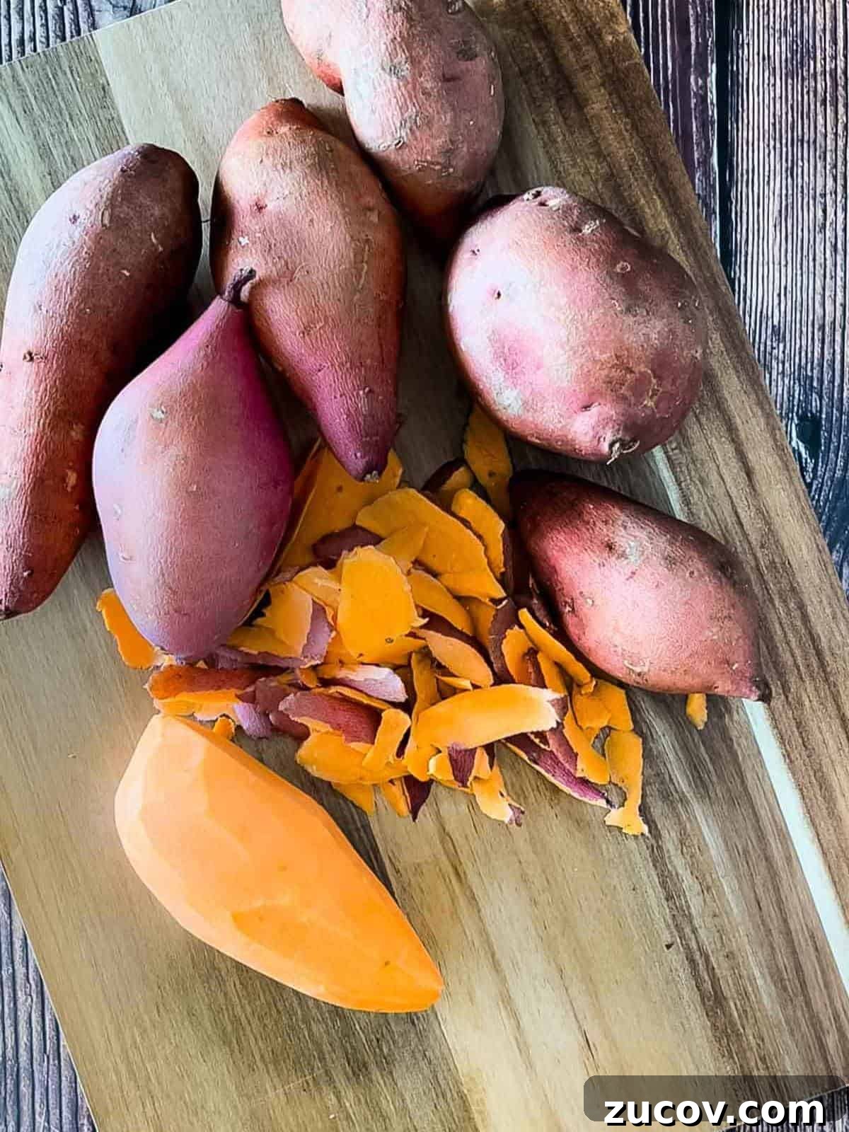 Crispy Air-Fryer Sweet Potato Fries Coated in Cornstarch 4 The sweet potatoes on a cutting board, with one of them peeled.