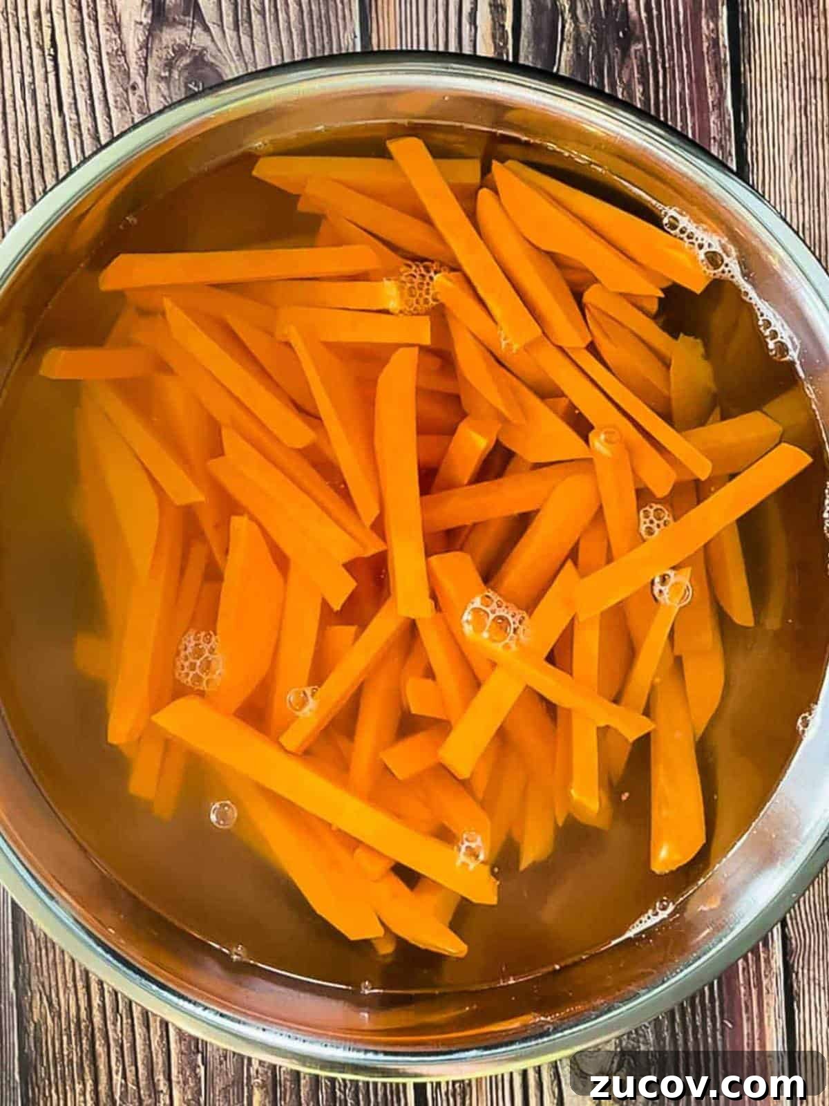 Crispy Air-Fryer Sweet Potato Fries Coated in Cornstarch 7 The sweet potato fries soaking in a large bowl of cold water.