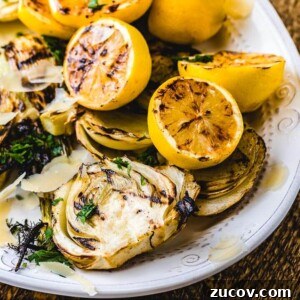 Grilled Fennel Salad with Shaved Parmesan and Lemon Vinaigrette 2 Grilled fennel and grilled lemons on white plate.
