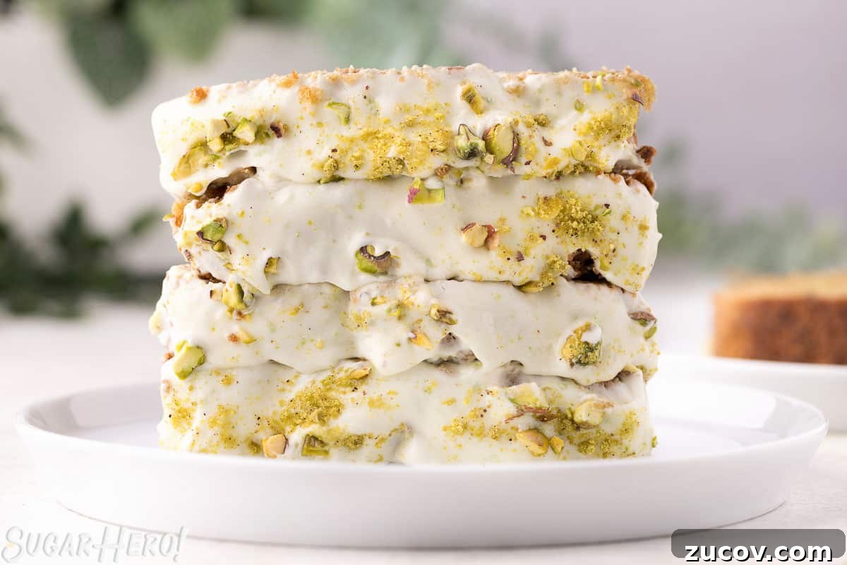 Moist Zucchini Bread Recipe with Cinnamon and Walnuts 11 Four slices of zucchini bread on a white plate, with cream cheese frosting and crushed pistachios on top.