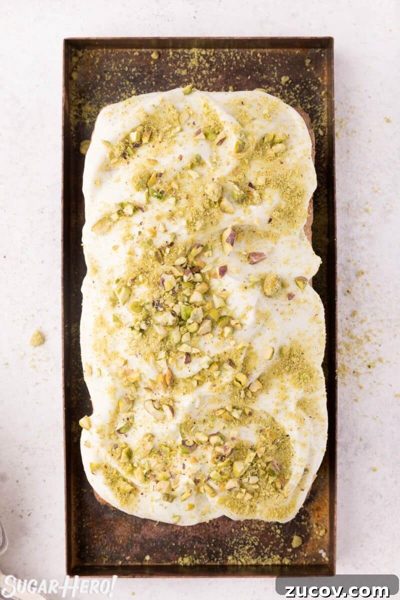 Moist Zucchini Bread Recipe with Cinnamon and Walnuts 3 Overhead shot of zucchini bread frosted with cream cheese frosting, with crushed pistachios sprinkled on top.