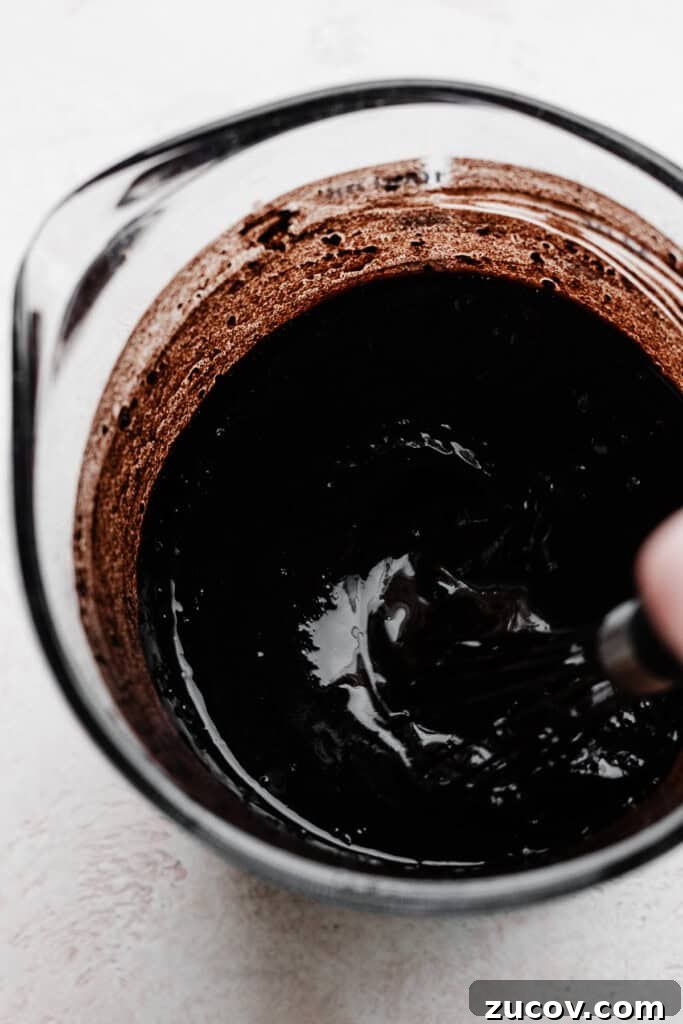 Decadent Peanut Butter Chocolate Cake Recipe You’ll Love 4 Wet ingredients for the chocolate cake being whisked.