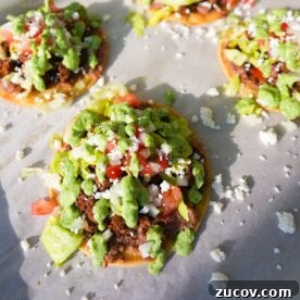 Crispy Ground Beef Tostadas with Fresh Salsa and Cheese 4 Ground beef tostadas topped with refried beans, lettuce, tomatoes, onions, queso fresco and cilantro lime sauce.