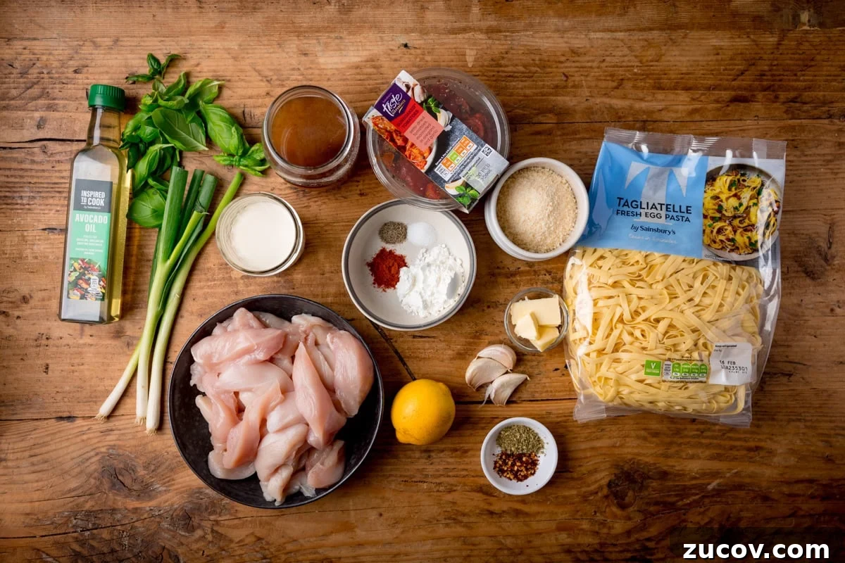 Creamy Marry Me Chicken Pasta Recipe for Weeknight Dinners 3 A wide, overhead shot pf the ingredients for Marry Me Chicken Pasta, laid out on a wooden cutting board.