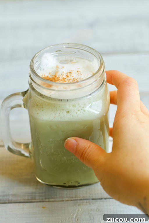 Matcha Chai Latte: Creamy Spiced Green Tea Recipe 3 Hand grabbing matcha chai latte
