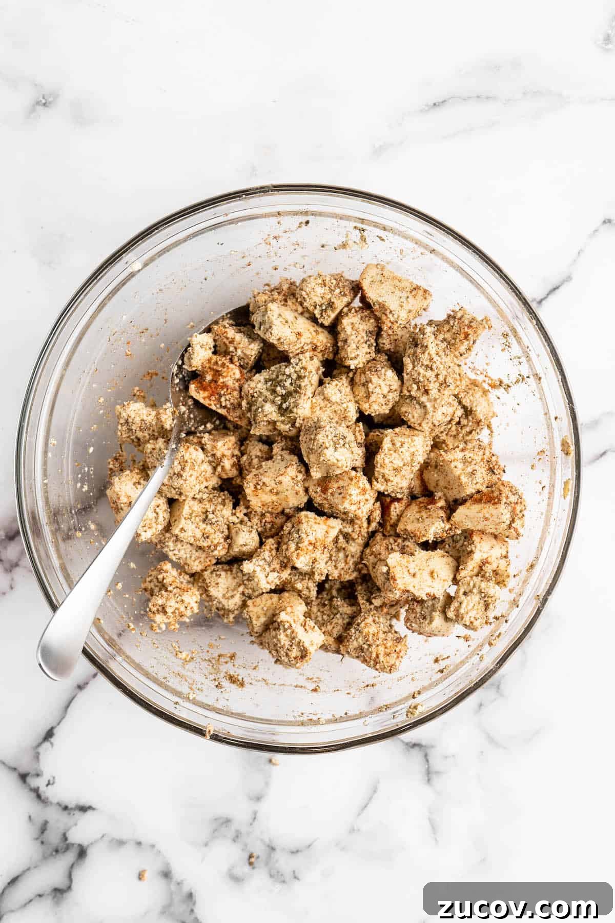 This Jamaican jerk tofu is the real deal! It's spicy, saucy, and just a little bit sweet. It's also super easy to make for a weeknight meal! Overhead view of marinated tofu in glass bowl