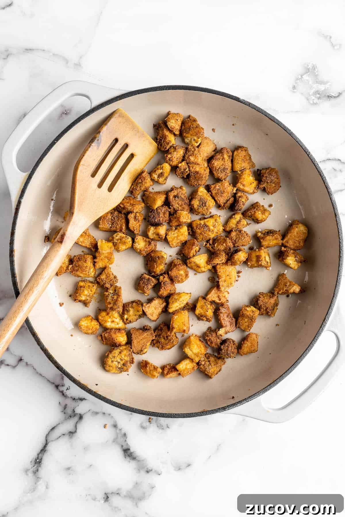 This Jamaican jerk tofu is the real deal! It's spicy, saucy, and just a little bit sweet. It's also super easy to make for a weeknight meal! Overhead view of tofu being cooked in skillet
