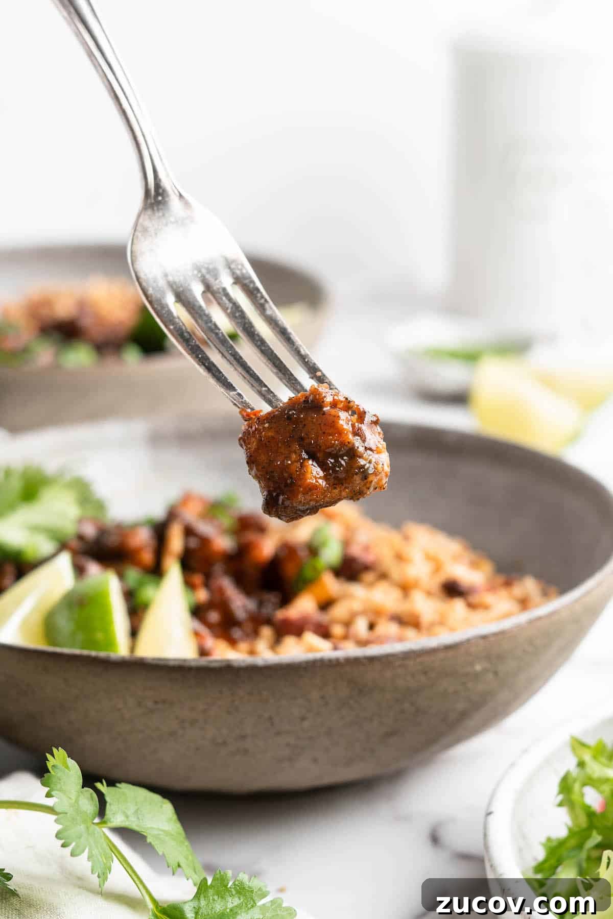 This Jamaican jerk tofu is the real deal! It's spicy, saucy, and just a little bit sweet. It's also super easy to make for a weeknight meal! Piece of Jamaican jerk tofu on fork