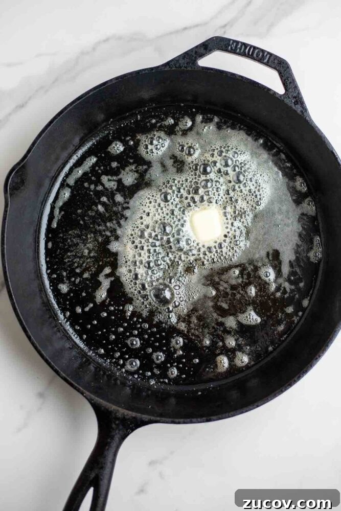 Blueberry Dutch Baby Pancake Recipe for Brunch and Dessert 5 Butter in a cast iron skillet.