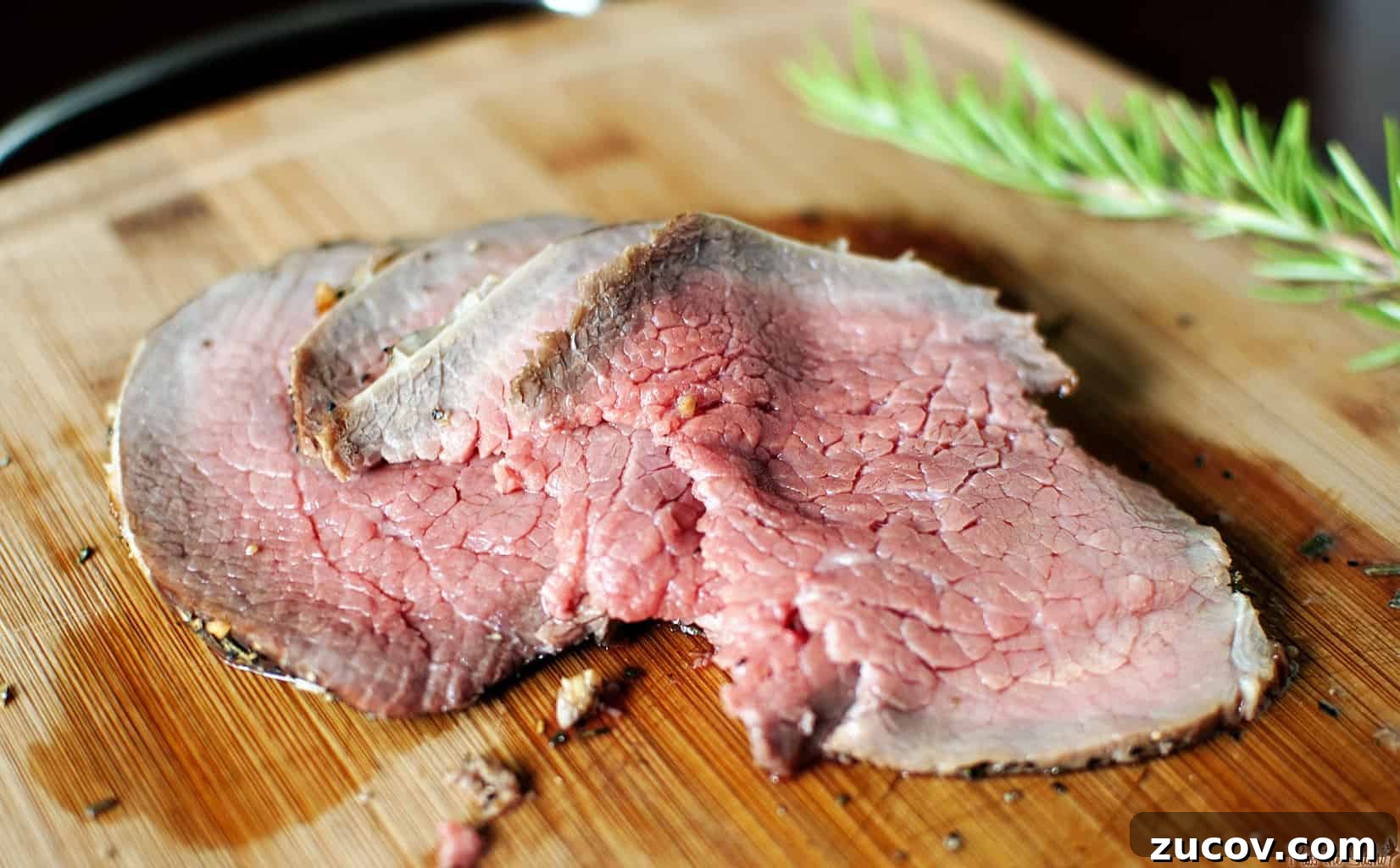 Grilling a Perfect Roast: Tips for Juicy, Flavorful Results 4 Slices of roast beef thats been grilled showing pink center for medium internal temp on a wooden cutting board.