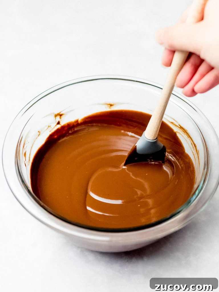 5-Minute Chocolate Ganache Recipe for Cakes, Glazes & Dips 4 chocolate ganache being made in a glass bowl with a spatula