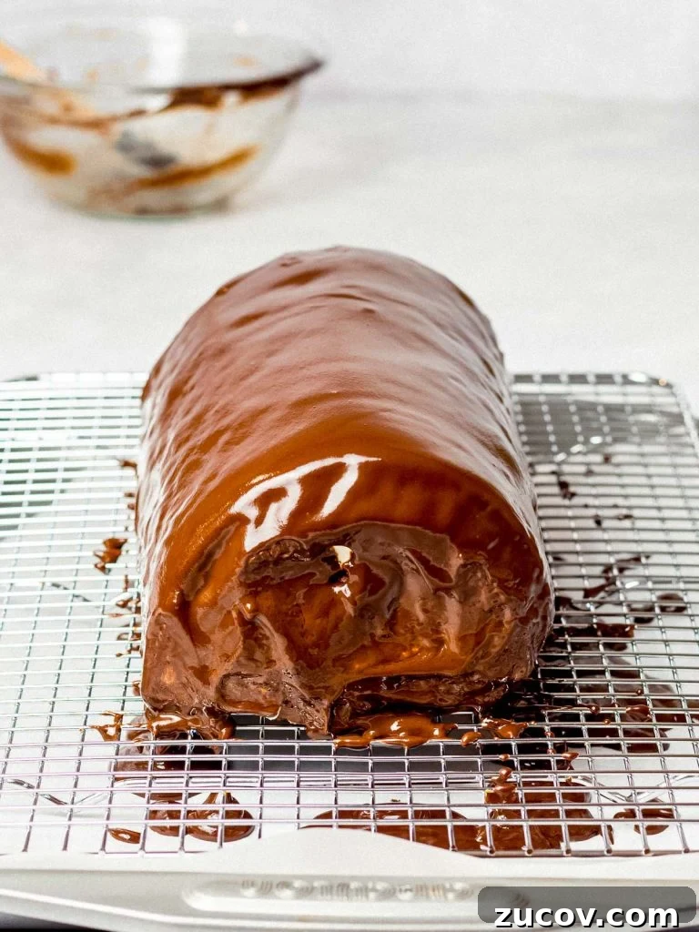5-Minute Chocolate Ganache Recipe for Cakes, Glazes & Dips 6 giant swiss roll cake with a chocolate ganache glaze on a cooking rack