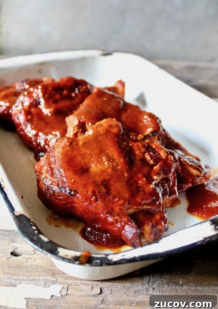 St. Louis Style BBQ Pork Steaks: Tender Grilled Recipe 7 St. Louis BBQ Pork Steaks close up shot in serving pan.
