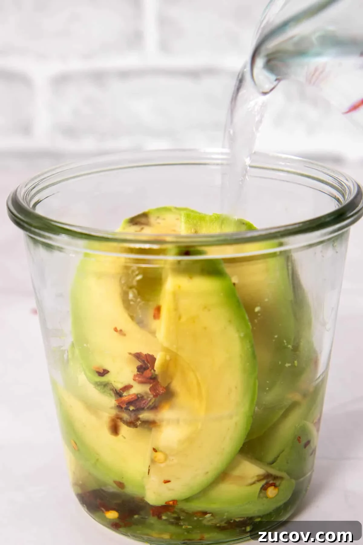 How to Make Pickled Avocados: A Simple Guide to Preserving Avocados 5 Pouring pickling liquid on avocados