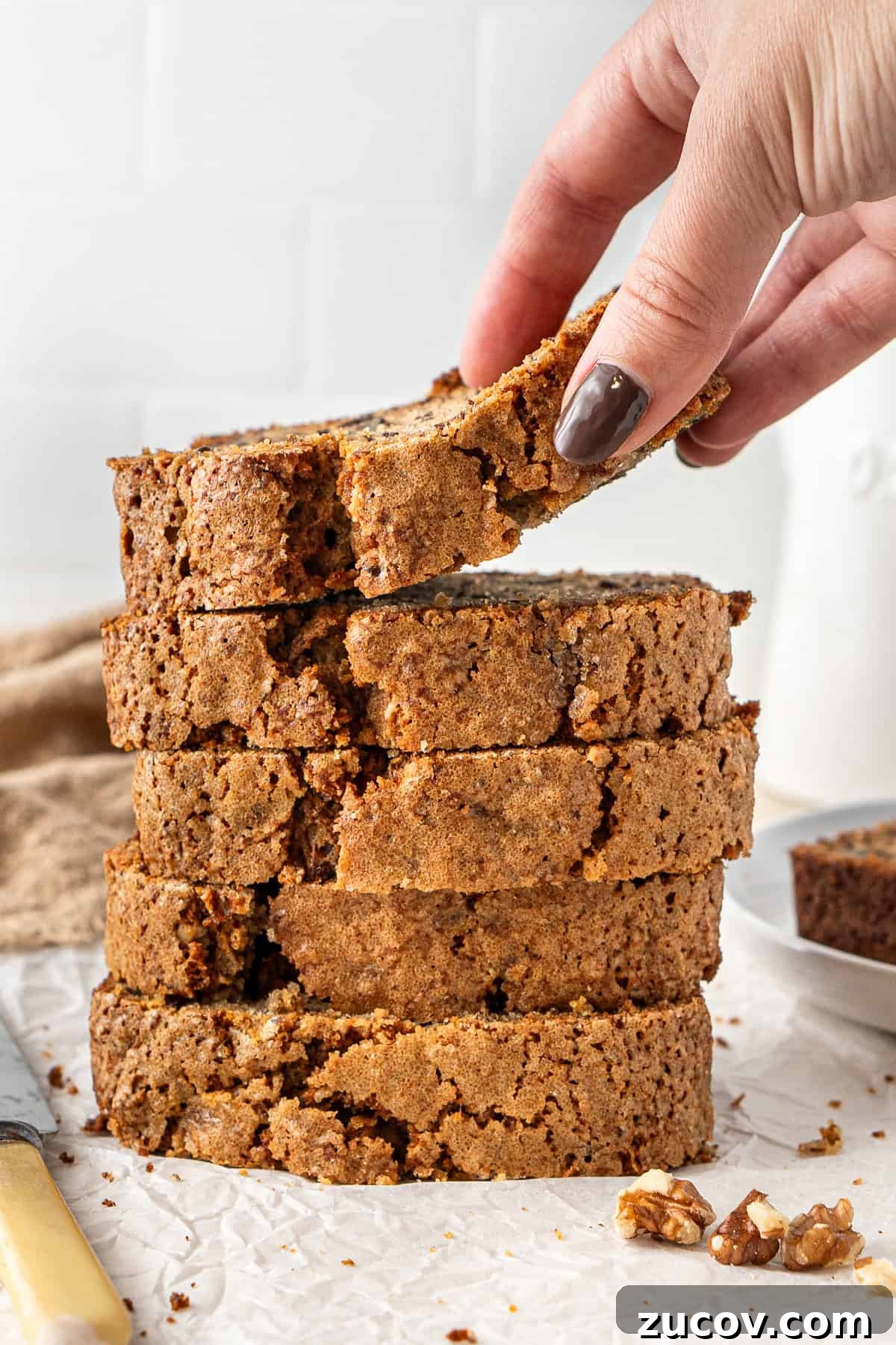 Ultimate Vegan Banana Bread Recipe You’ll Love 13 A hand picking up a slice of banana bread.