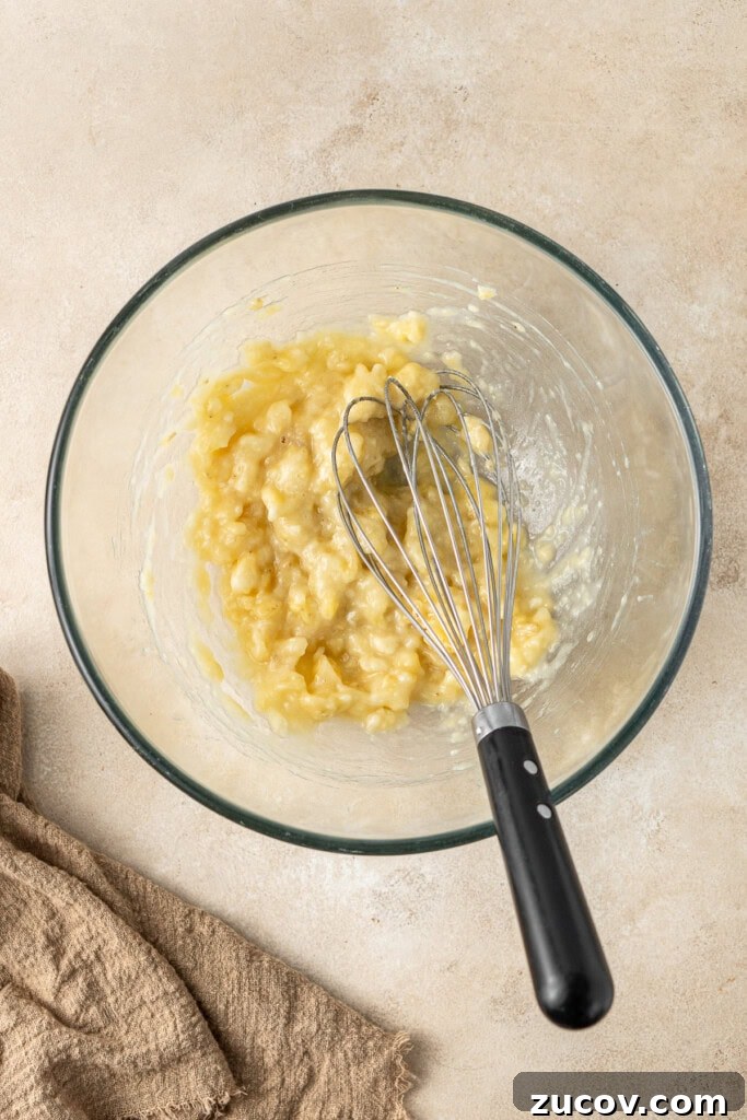 Ultimate Vegan Banana Bread Recipe You’ll Love 7 Mashing the banana in a mixing bowl.