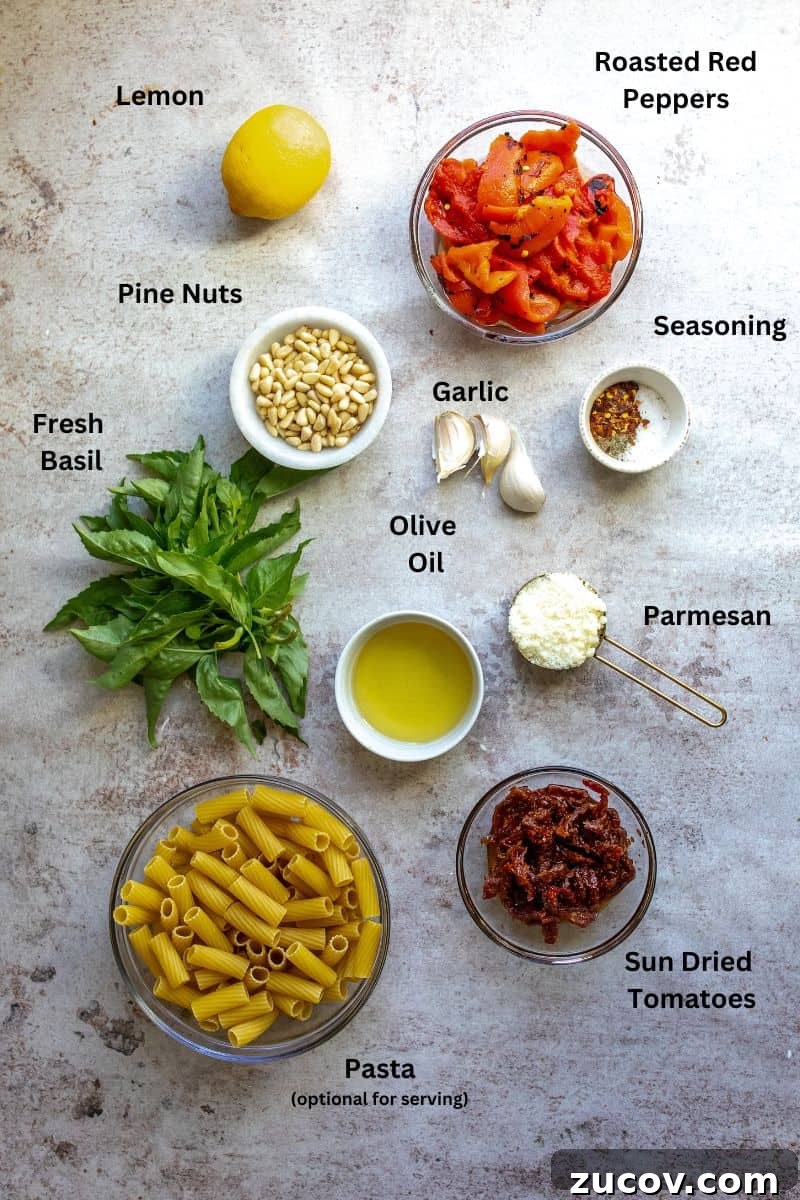 Roasted Red Pepper Pesto Recipe for Pasta, Sandwiches & Dips 3 Glass bowls with ingredients in them and fresh herbs all on a counter.