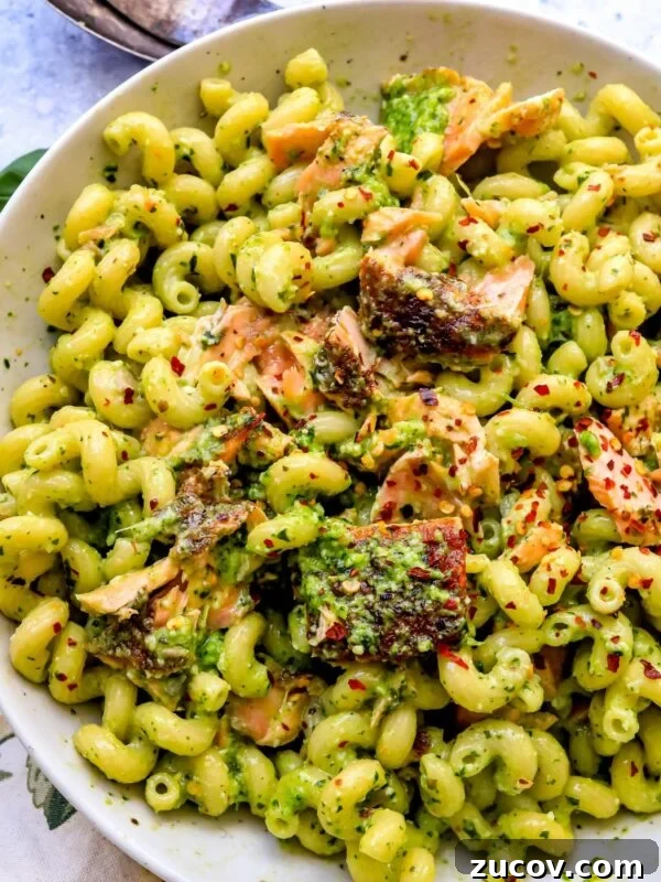 Roasted Red Pepper Pesto Recipe for Pasta, Sandwiches & Dips 8 pesto pasta and salmon in a white dish and a towel to the side.