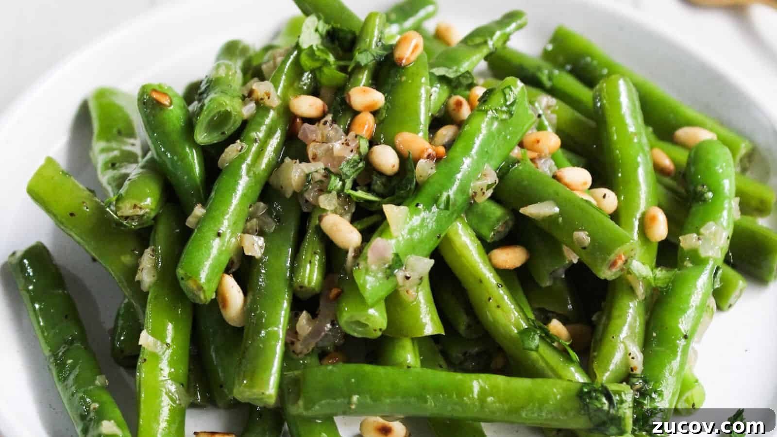 17 Comforting Side Dishes That Steal the Show 19 Green beans with pine nuts on a plate.