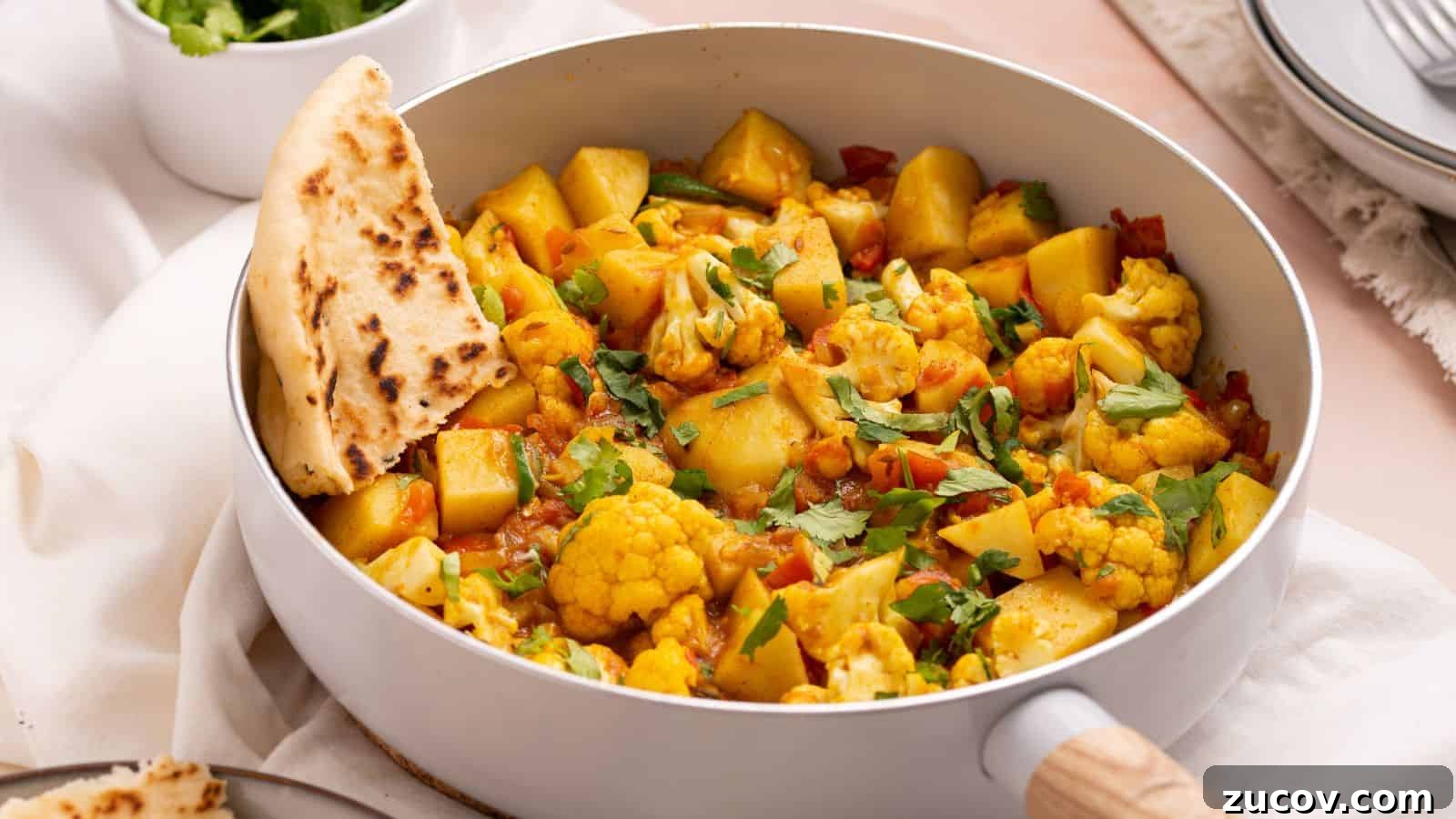 17 Comforting Side Dishes That Steal the Show 5 Aloo gobi masala in skillet with naan bread.