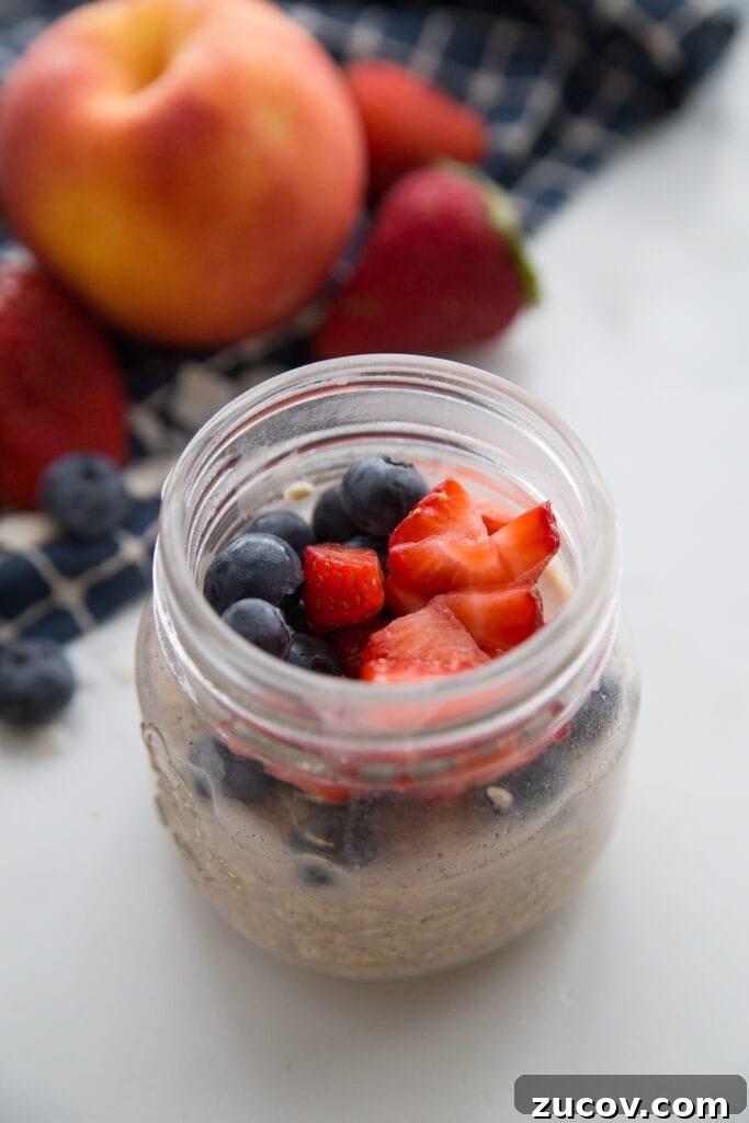 Creamy Overnight Oats: 5 Simple Recipes for Busy Mornings 11 A jar of very berry overnight oats topped with blueberries and strawberries