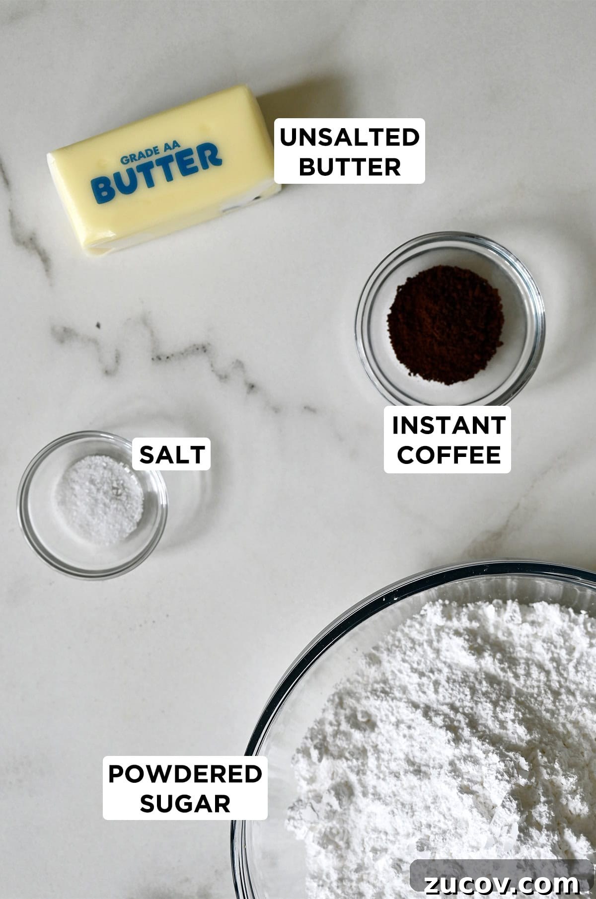 5-Minute Coffee Buttercream Frosting Recipe 4 A stick of butter next to a small bowl with instant coffee, a medium bowl with powdered sugar and a small bowl with salt.