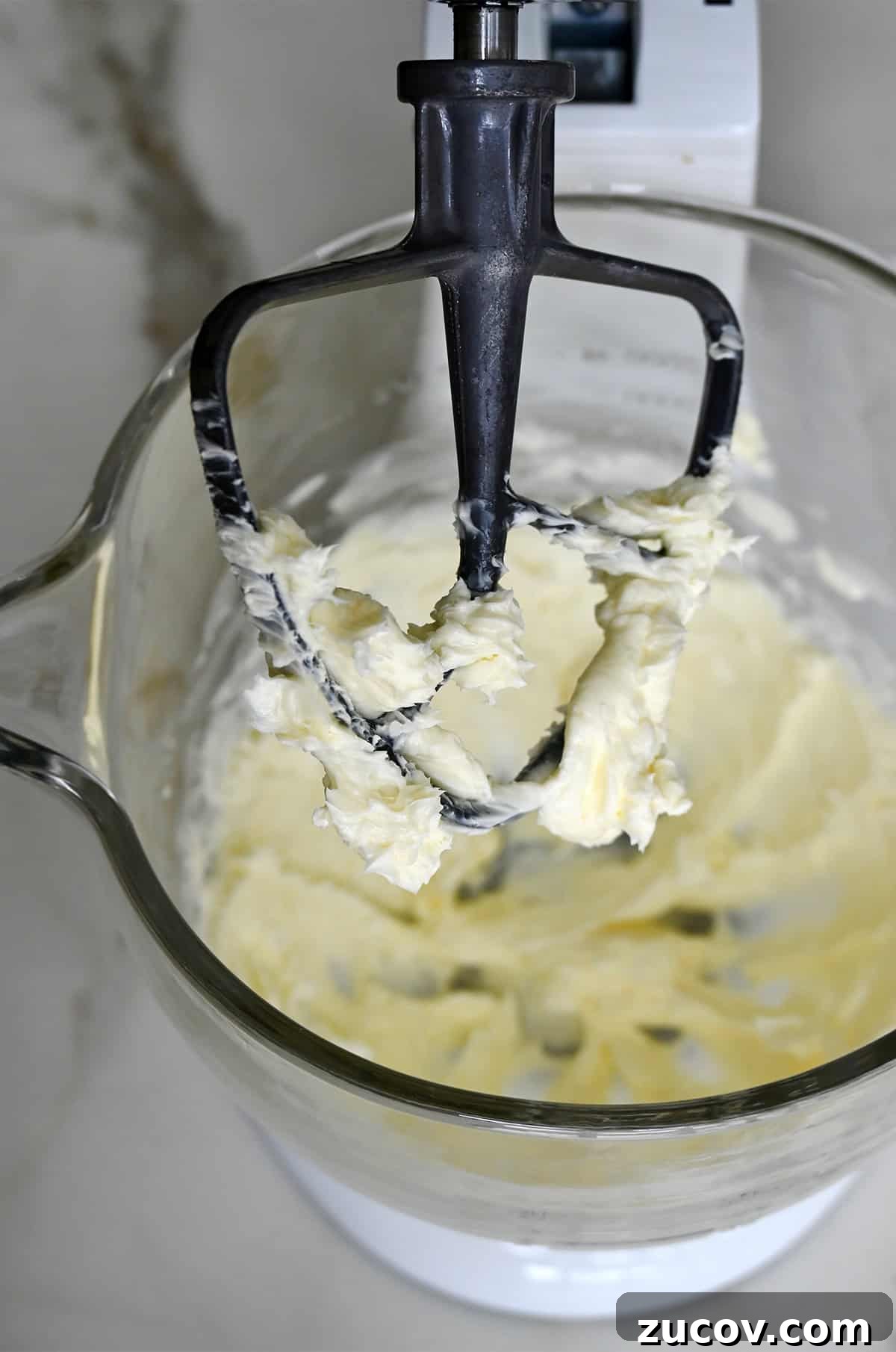 5-Minute Coffee Buttercream Frosting Recipe 5 The paddle attachment of a stand mixer covered in whipped butter.