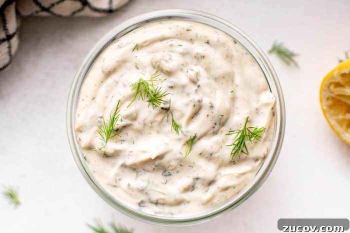Creamy Homemade Tartar Sauce Recipe for Fish and Seafood 12 Overhead view of a glass jar filled with tartar sauce, garnished with dill sprigs.