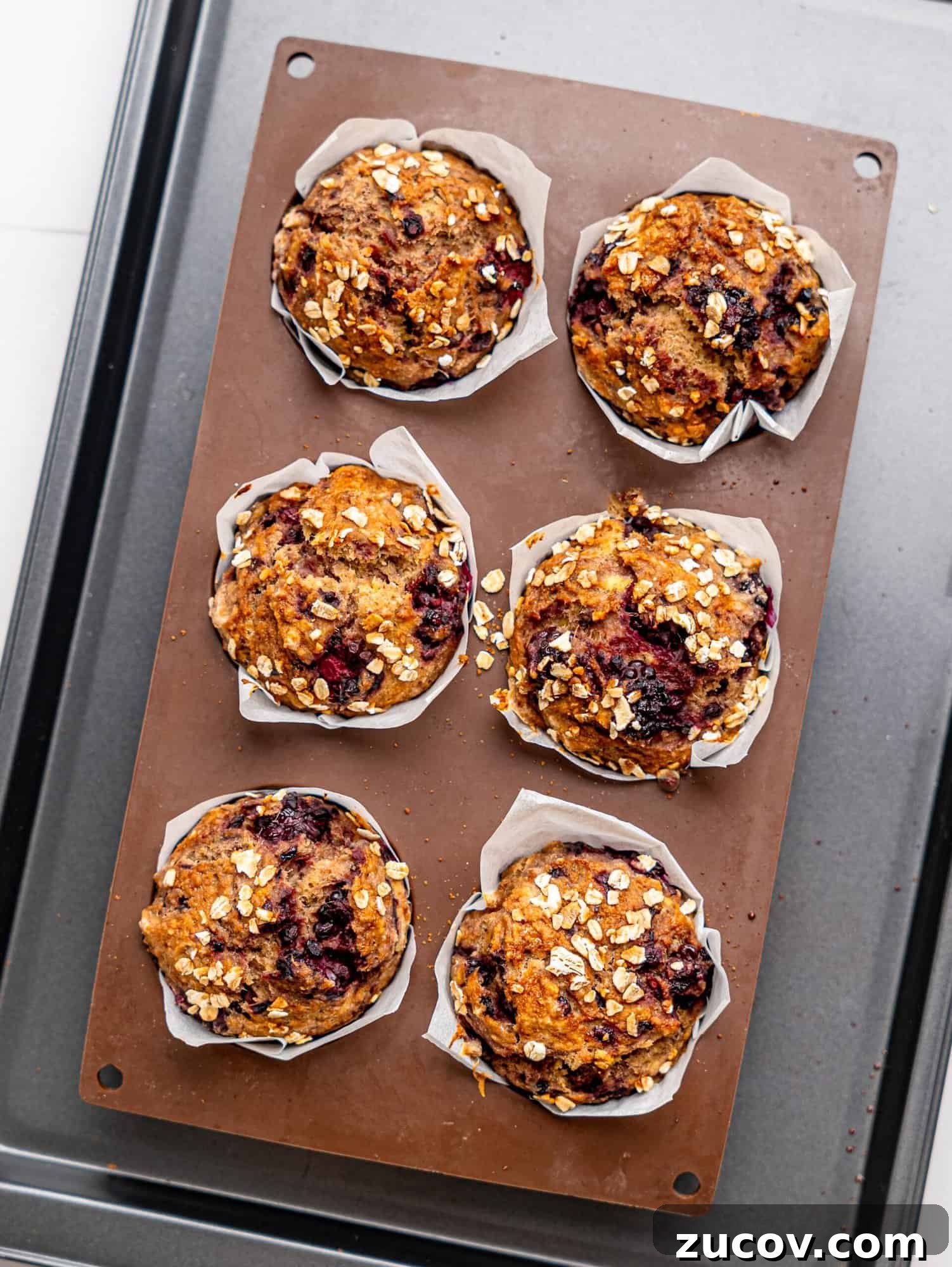 Banana Blackberry Muffins with 5 Simple Ingredients 9 Banana Blackberry Oatmeal Muffins in a silicone muffin tray.