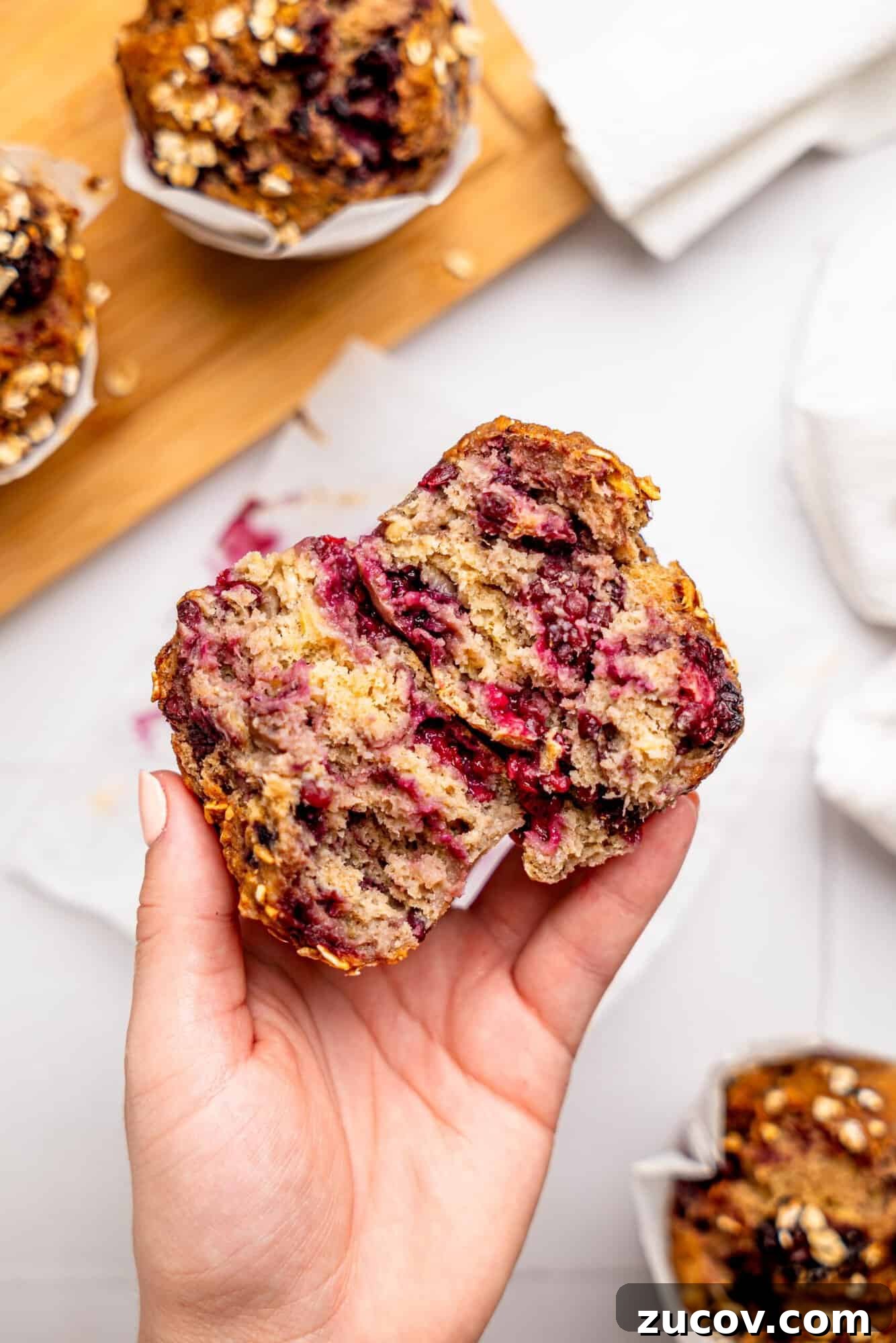 Banana Blackberry Muffins with 5 Simple Ingredients 5 Hand holding a banana blackberry muffin, broken in half.